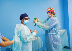 外科手术开始前, 两名助手穿上女外科医生的衣服。
