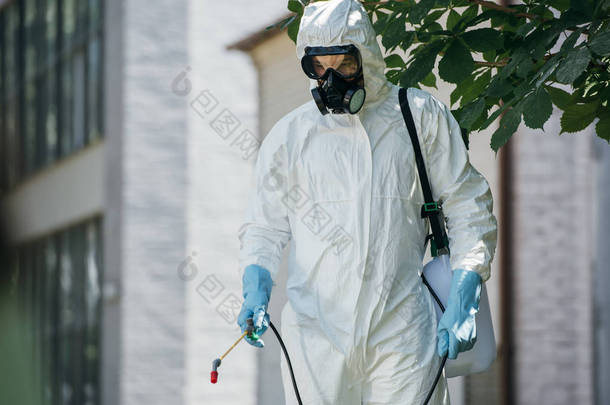 害虫防治工作者喷洒杀虫剂在街道上用喷雾器  