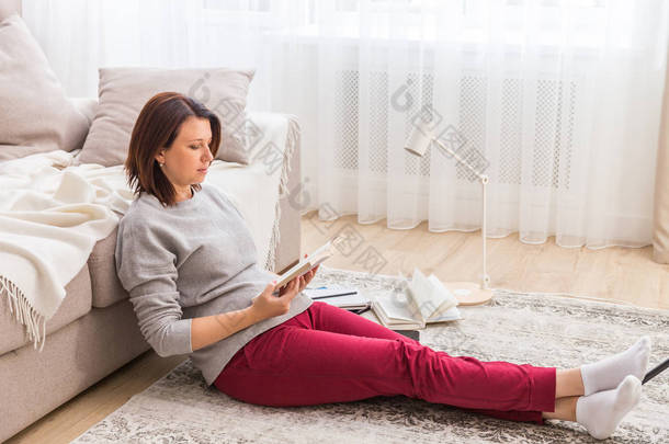 在家看书的年轻妇女放松地板