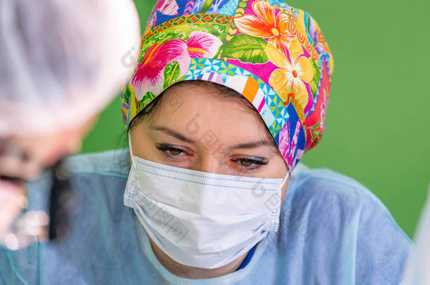 女外科<strong>医生</strong>在手术中戴着防护面具和<strong>帽子</strong>。医疗保健、医学教育、急救医疗、手术理念.