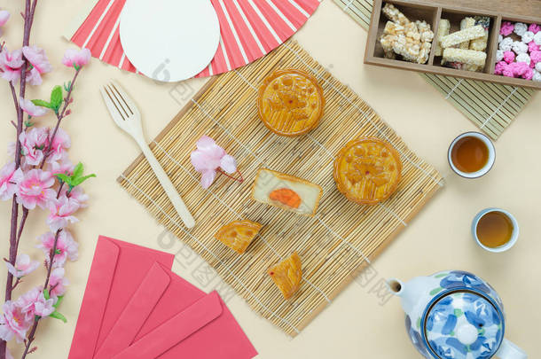 桌面上观看空中装饰的图片中国中秋节或农历新年背景概念。平卧精餐集甜饼茶与黄纸花泡茶.