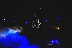 空中杂技演员在圆环。一个年轻女孩在空气环中表演杂技元素.