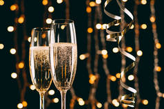 香槟在玻璃和丝带上花环浅色背景, 圣诞节概念