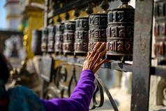 尼泊尔加德满都 swayambhunath stupa 祈祷轮上散步的老年妇女