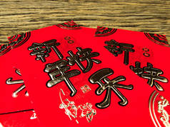 红色信封在木背景与2月礼物中国新年。信封上的中文文本, 意思是中国新年快乐.