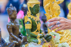 在每年4月13日的宋干节上, 泰国民众在沐浴仪式的同时, 都会在佛像中亲密接触。佛教徒正在沐浴佛像, 以获得泰国新年期间的功绩. 