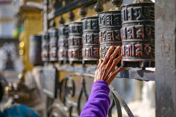 在 swayambhunath stupa 绕着祈祷车轮行走的妇女