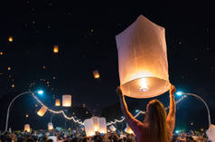 在泰国清迈的 loy krathong 节日或浮动灯笼节中释放漂浮灯笼的妇女.