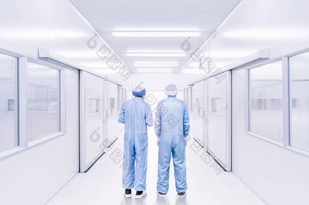 现代室内实验室或工厂有两个科学工作者的背后, 在工作服制服, 科学发展理念背景