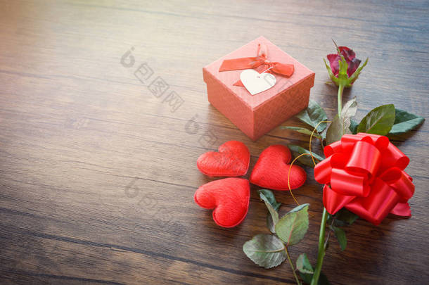情人节<strong>礼品</strong>盒红色在木头背景/浪漫的红色心脏情人节红色玫瑰花和礼物<strong>箱</strong>子丝带弓在老木头-爱概念顶视图拷贝空间