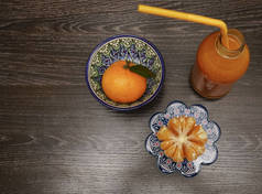 新鲜果汁由黑木桌背景上的橘子制成。顶部视图。静静的生活.