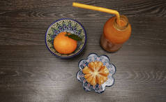 新鲜果汁由黑木桌背景上的橘子制成。顶部视图。静静的生活.