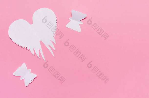 白色天使翅膀和蝴蝶剪纸在粉红色的背景, 复活节和春天概念与复制空间.