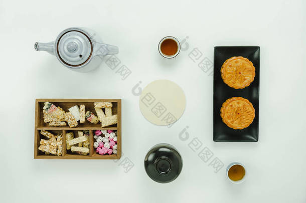 桌面视图航拍图像农历新年 & 中国新年概念背景。平躺基本的脚 & 饮料餐设置甜甜点 & 茶与月饼在现代质朴的白纸.