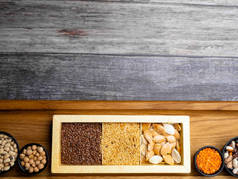 不同种类的豆籽、小扁豆、木桌上盘子里的豌豆、大型生物食品或健康食品、复印空间