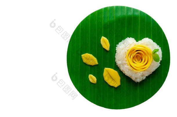 芒果糯米和椰奶装饰为爱情形状 & 玫瑰放在香蕉叶上。这是泰国夏天著名的甜点, 是芒果季节, 在白色的背景上被隔离, 有文字空间.