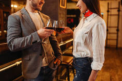 男人和女人在木吧柜台喝红酒。情侣在酒吧休闲, 丈夫和妻子一起在夜总会放松