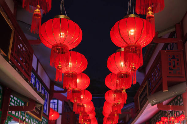 传统的中国红色之夜户外休闲吊灯与金色的传送带装饰装饰路灯, 建筑物和商店为中国新年节日季节庆祝活动