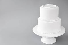 白色婚礼蛋糕空白在灰色背景。简单的简约主义.