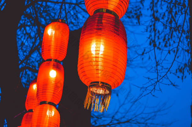 公园里的树上有中国橙色的小灯。夜晚灯火通明的<strong>街道</strong>。<strong>照明</strong>.