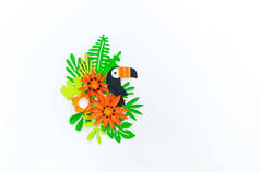 热带叶子和花卉的装饰布置。用纸做的图坎鸟.