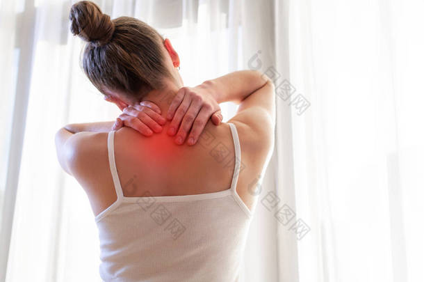 年轻女子因颈部疼痛而按摩脖子, <strong>伸展</strong>肌肉. 