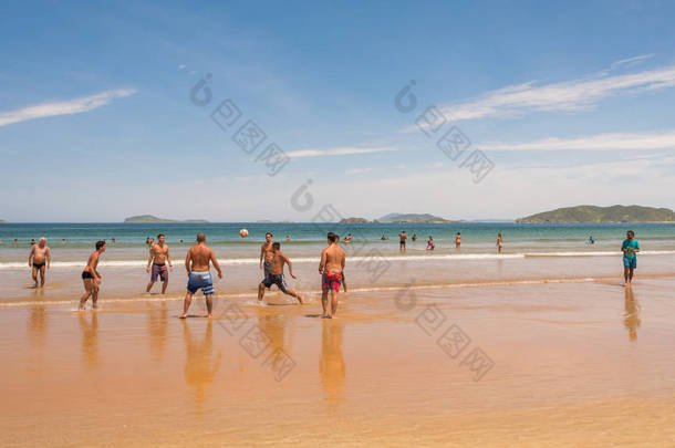 Buzios， 里约热内卢 / 巴西 - 2016年2月28日： 令人难以置信的<strong>夏季</strong>阳光明媚的日子在Geriba海滩与一群当地人和游客在清澈的海水附近的沙滩上踢足球