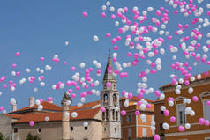 粉红色和白色的气球在蓝天的历史中心 