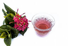 红色五角花或埃及星花或茉莉花的特写，在白色上分离，其提取的草药和药用茶在一个小的透明玻璃碗.