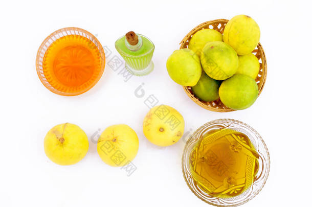 柠檬头发生长面膜分离在白色，即柠檬汁与蜂蜜和橄榄油混合在玻璃碗与整个原料.