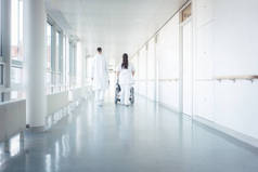医生、护士和病人坐在医院走廊的轮椅上