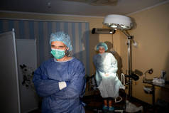 照片上是一个平静的外科医生，背后有一个兴奋的病人。 外科准备工作