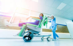 护士与病人一起在医院移动移动医疗椅。 医疗设备。 模糊的抽象背景。 概念