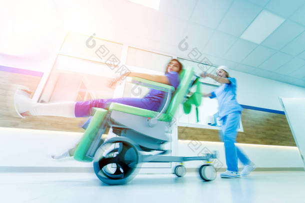 护士与病人一起在医院<strong>移动移动医疗</strong>椅。 <strong>医疗</strong>设备。 模糊的抽象背景。 概念