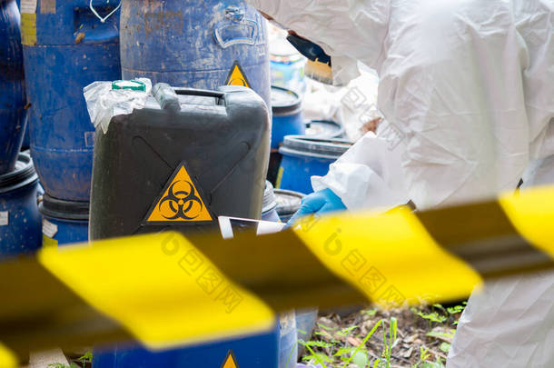 亚洲科学家穿着化学防护服检查危险化学品，在危险区域工作，验证危险化学品