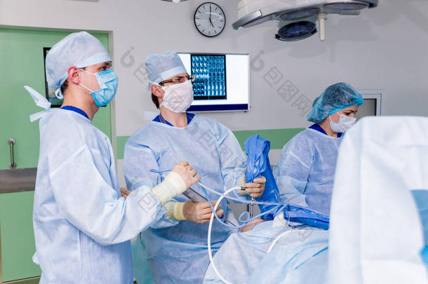 关节镜手术。外科整形外科医生在手术室用现代关节镜工具进行协同工作。膝盖手术。医院背景