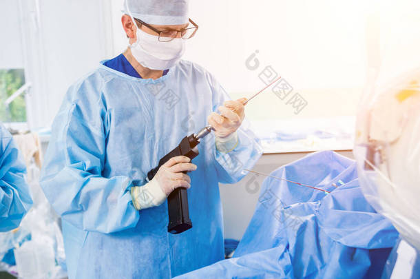 关节镜手术。 外科<strong>整形</strong>外科医生在手术室用现代关节镜工具进行协同工作。 医院背景