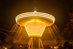 一个模糊的五彩缤纷的旋转木马在游乐园，夜间照明。 长期接触.