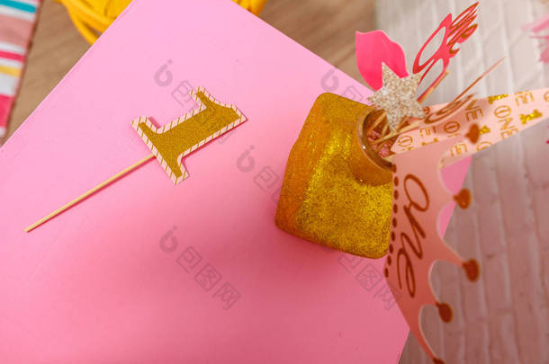 庆祝生日第一年的纸制道具。 为小女孩装饰粉色风格的一岁生日宴会的想法。 时尚道具为展位拍摄一年照片