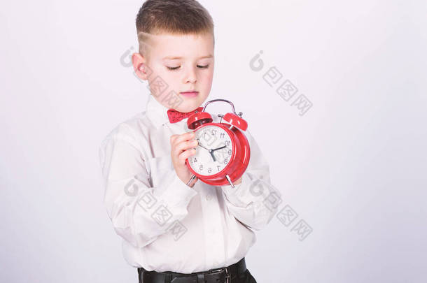 设置<strong>闹钟</strong>。小男孩拿着红钟。是时候了时间表和时间。早上例行公事。带<strong>闹钟</strong>的小学生。孩子可爱的男孩白衬衫红色领结。发展自律