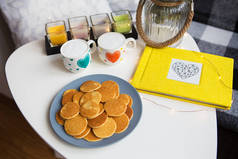 桌上放着两杯咖啡和美味的薄饼，黄色相册，特写