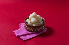 印度甜食或甜点-拉斯古拉，著名的孟加拉甜食在粘土碗与红底餐巾