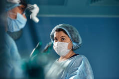 两名穿着防护服的外科医生在手术过程中，在手术室的背景下。 从观点出发