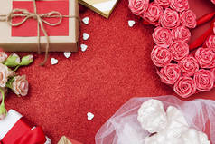 红色的背景闪烁着红心，礼物，鲜花。 情人节贺卡的空余空间