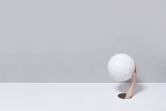 把洞交出来 一个小孩的手拿着一个灰色和白色背景的白色排球球