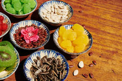 向日葵、西瓜、南瓜种子和干果放在木制桌子上的小碗里庆祝
