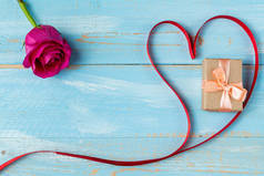 蓝色木制背景上的心形带子和礼品盒。 情人节礼物