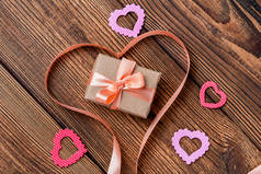 心形缎带、礼物和粉色背景的花朵。 情人节礼物