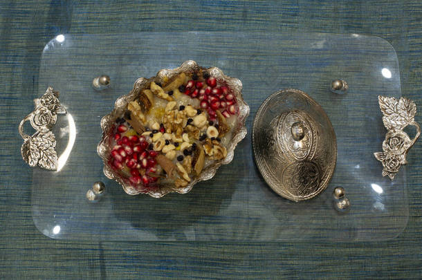 传统的甜点果冻，阿舒拉，诺亚的<strong>布丁</strong>，放在木制圆板上的碗里。从上往下看，用斜<strong>体</strong>字<strong>体</strong>用英文书写：阿舒拉日，土耳其文.