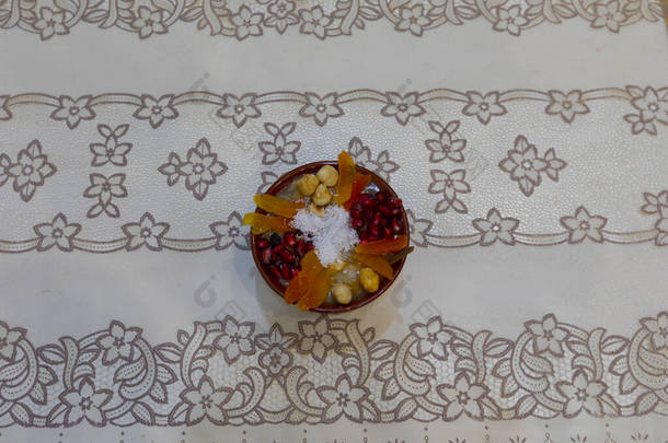 传统的甜点果冻，阿舒拉，诺亚的布丁，放在木制圆板上的碗里。从上<strong>往下</strong>看，用斜体字体用英文书写：阿舒拉日，土耳其文.